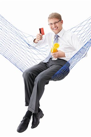 Young businessman with credit card and a cocktail in a hammock isolated Stock Photo - Budget Royalty-Free & Subscription, Code: 400-04398303