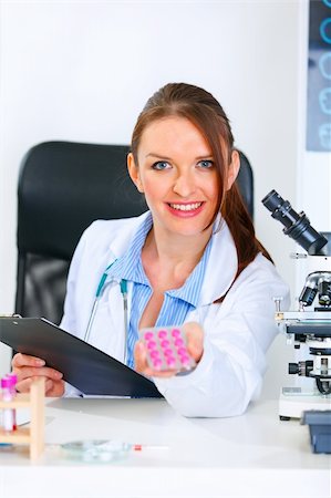 simsearch:400-04925813,k - Smiling medical doctor woman sitting at office table and giving prescription drugs Stock Photo - Budget Royalty-Free & Subscription, Code: 400-04390416