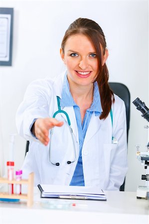simsearch:400-04390415,k - Smiling medical doctor woman stretches out hand for handshake in office Stock Photo - Budget Royalty-Free & Subscription, Code: 400-04390419