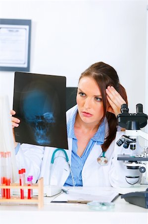 simsearch:400-04390415,k - Concentrated medical doctor woman sitting at office table and analyzing patients roentgen Stock Photo - Budget Royalty-Free & Subscription, Code: 400-04390410