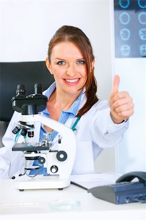 simsearch:400-04925813,k - Smiling medical doctor woman using microscope in laboratory and showing thumbs up gesture Stock Photo - Budget Royalty-Free & Subscription, Code: 400-04390411