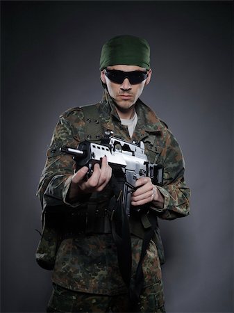 simulation - Young soldier in camouflage and ammunition with a gun. studio shot Stock Photo - Budget Royalty-Free & Subscription, Code: 400-04390871