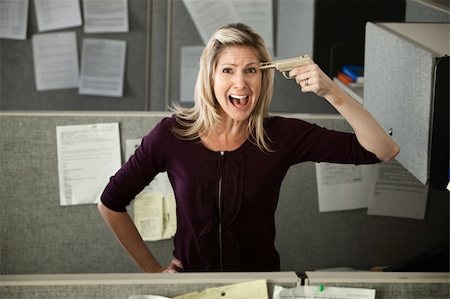 Woman office worker gestures to shoot self in the head with toy pistol Stock Photo - Budget Royalty-Free & Subscription, Code: 400-04391523