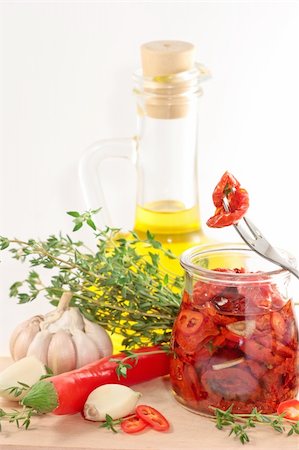 sonnengetrocknet - Marinated dried tomatoes, garlic, olive oil, thyme. Stockbilder - Microstock & Abonnement, Bildnummer: 400-04393716