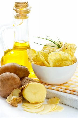 simsearch:400-07294321,k - Potato chips, raw potato and jug of olive oil. Photographie de stock - Aubaine LD & Abonnement, Code: 400-04393766