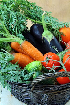 Mix fresh vegetables (carrots, eggplant, cucumbers, tomatoes) in a black wicker basket Stock Photo - Budget Royalty-Free & Subscription, Code: 400-04404545