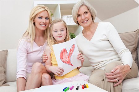 Three female generations of one family at home. Mother, grandmother and daughter who is holding a hand drawn picture of a red heart. Love or healthy living concept. Stock Photo - Budget Royalty-Free & Subscription, Code: 400-04404942