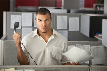 Frustrated office worker with papers holds a phone away from his ear Stock Photo - Budget Royalty-Free & Subscription, Code: 400-04405067