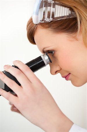 simsearch:400-04548222,k - Scientist carrying out an experiment looking through a microscope in a lab Stockbilder - Microstock & Abonnement, Bildnummer: 400-04405894
