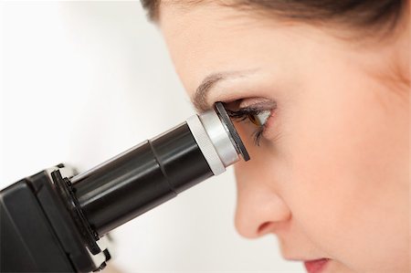 simsearch:400-05670345,k - Dark-haired scientist looking through a microscope in a lab Photographie de stock - Aubaine LD & Abonnement, Code: 400-04405890