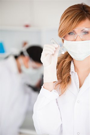Cute scientist woman holding a test tube looking at the camera in a lab Stock Photo - Budget Royalty-Free & Subscription, Code: 400-04405907