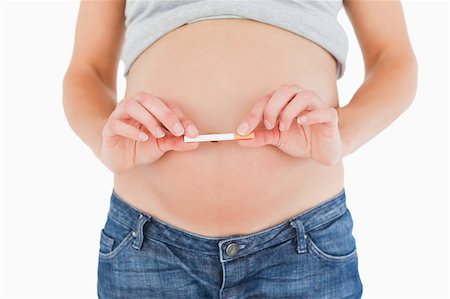 smoke isolated - Pregnant woman holding a cigarette while standing against a white background Stock Photo - Budget Royalty-Free & Subscription, Code: 400-04406026