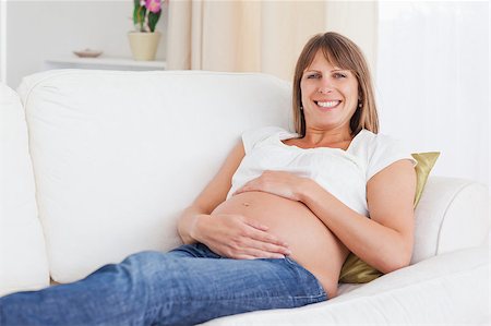 simsearch:400-04688796,k - Good looking pregnant woman posing while lying on a sofa in her apartment Fotografie stock - Microstock e Abbonamento, Codice: 400-04406112