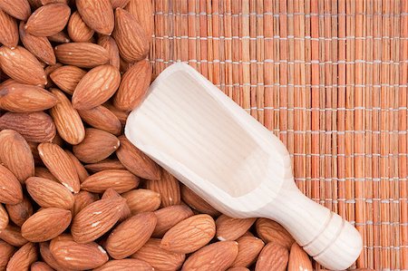 Nuts Almond are scattered as a background on a wooden mat. Photographie de stock - Aubaine LD & Abonnement, Code: 400-04406385