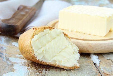 spreading butter on bread - fresh yellow butter and fresh bread on a wooden table Stock Photo - Budget Royalty-Free & Subscription, Code: 400-04407221