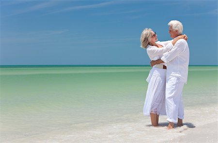 simsearch:400-05711437,k - Happy senior man and woman embracing on a deserted tropical beach with bright clear blue sky Stock Photo - Budget Royalty-Free & Subscription, Code: 400-04408392