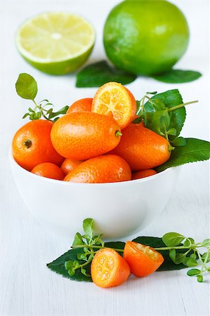 simsearch:400-07506471,k - Delicious kumquats in a white ceramic bowl on a garden board. Foto de stock - Royalty-Free Super Valor e Assinatura, Número: 400-04409945