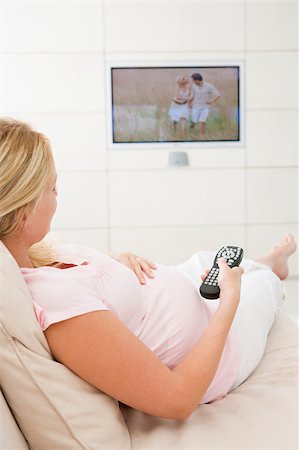 simsearch:400-04045202,k - Pregnant woman watching television using remote control Stock Photo - Budget Royalty-Free & Subscription, Code: 400-04400602