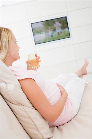 Pregnant woman watching television with glass of white wine Stock Photo - Budget Royalty-Free & Subscription, Code: 400-04400621