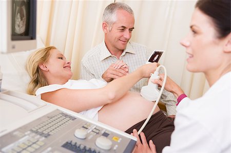 pregnant scan - Pregnant woman getting ultrasound from doctor with husband looki Foto de stock - Super Valor sin royalties y Suscripción, Código: 400-04400687