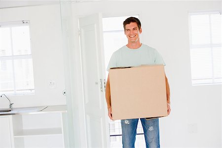 Man with box moving into new home smiling Stock Photo - Budget Royalty-Free & Subscription, Code: 400-04400769