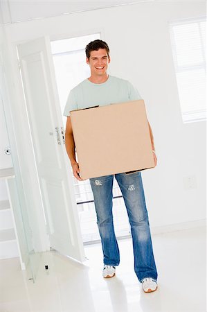 Man with box moving into new home smiling Stock Photo - Budget Royalty-Free & Subscription, Code: 400-04400770