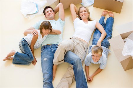 simsearch:400-04047615,k - Family lying on floor by open boxes in new home smiling Foto de stock - Super Valor sin royalties y Suscripción, Código: 400-04400789