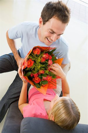 simsearch:659-03527445,k - Husband giving wife flowers and smiling Photographie de stock - Aubaine LD & Abonnement, Code: 400-04401470