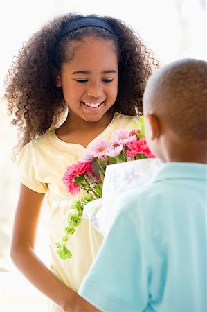 simsearch:659-03527445,k - Young boy giving young girl flowers and smiling Photographie de stock - Aubaine LD & Abonnement, Code: 400-04401520