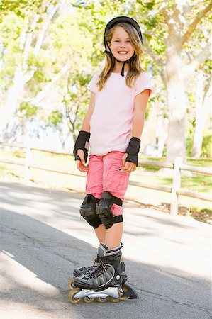 rollerblade girl - Young girl outdoors on inline skates smiling Stock Photo - Budget Royalty-Free & Subscription, Code: 400-04402038