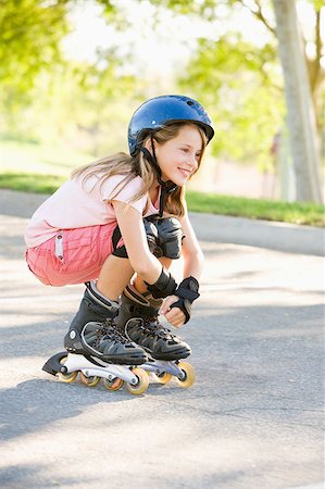 rollerblade girl - Young girl outdoors on inline skates smiling Stock Photo - Budget Royalty-Free & Subscription, Code: 400-04402039