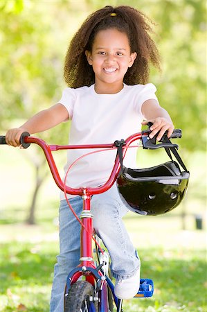 simsearch:400-04402106,k - Young girl on bicycle outdoors smiling Fotografie stock - Microstock e Abbonamento, Codice: 400-04402040