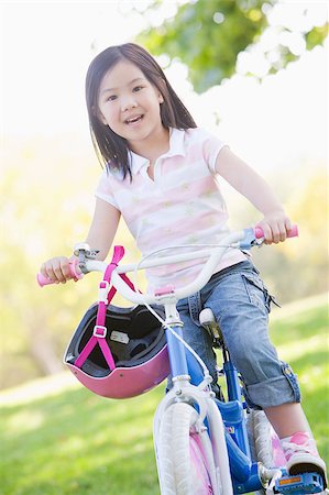 simsearch:400-04402106,k - Young girl on bicycle outdoors smiling Fotografie stock - Microstock e Abbonamento, Codice: 400-04402052