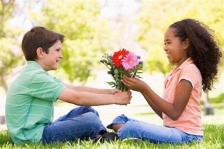 Young boy giving young girl flowers and smiling Stock Photo - Budget Royalty-Free & Subscription, Code: 400-04402060