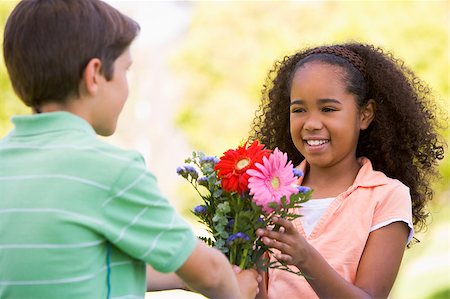 Young boy giving young girl flowers and smiling Stock Photo - Budget Royalty-Free & Subscription, Code: 400-04402061