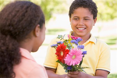 Young boy giving young girl flowers and smiling Stock Photo - Budget Royalty-Free & Subscription, Code: 400-04402076