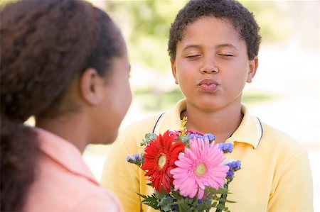 Young boy giving young girl flowers and puckering up Stock Photo - Budget Royalty-Free & Subscription, Code: 400-04402077
