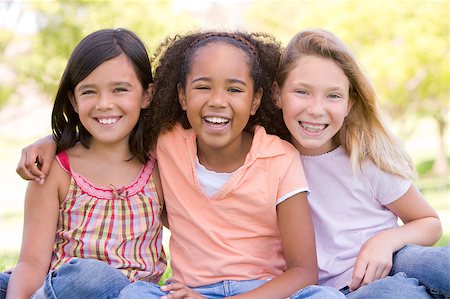 simsearch:400-04402106,k - Three young girl friends sitting outdoors smiling Fotografie stock - Microstock e Abbonamento, Codice: 400-04402071