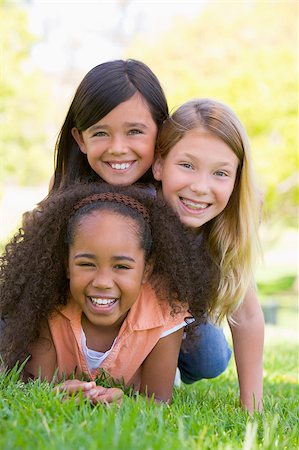 simsearch:400-04402106,k - Three young girl friends piled up on top of each other outdoors Fotografie stock - Microstock e Abbonamento, Codice: 400-04402072