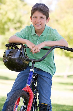 simsearch:400-04402106,k - Young boy on bicycle outdoors smiling Fotografie stock - Microstock e Abbonamento, Codice: 400-04402094