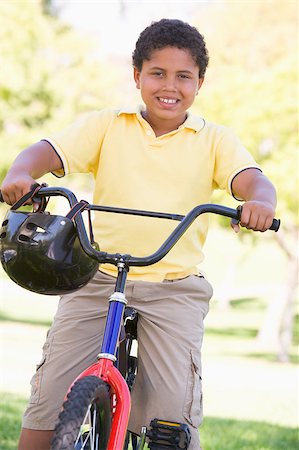 simsearch:400-04402106,k - Young boy on bicycle outdoors smiling Fotografie stock - Microstock e Abbonamento, Codice: 400-04402095