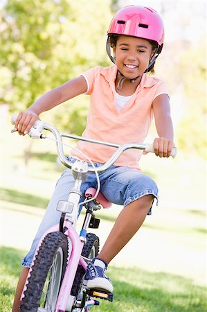 simsearch:400-04402106,k - Young girl on bicycle outdoors smiling Fotografie stock - Microstock e Abbonamento, Codice: 400-04402097