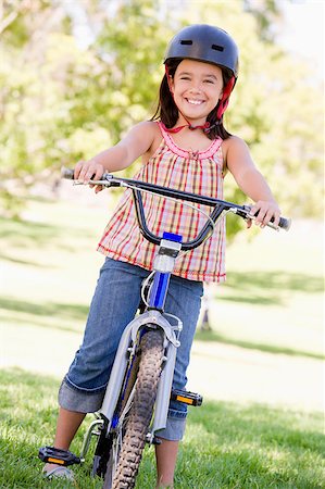 simsearch:400-04402100,k - Young girl on bicycle outdoors smiling Stock Photo - Budget Royalty-Free & Subscription, Code: 400-04402099