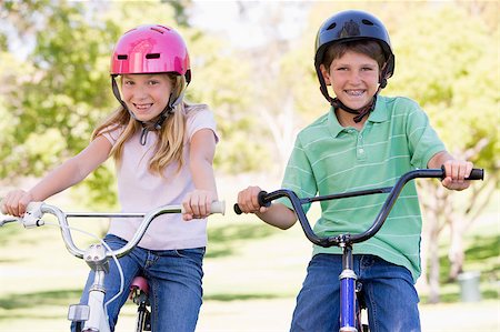 simsearch:400-04402100,k - Brother and sister outdoors on bicycles smiling Stock Photo - Budget Royalty-Free & Subscription, Code: 400-04402092