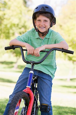 simsearch:400-04402106,k - Young boy on bicycle outdoors smiling Fotografie stock - Microstock e Abbonamento, Codice: 400-04402093