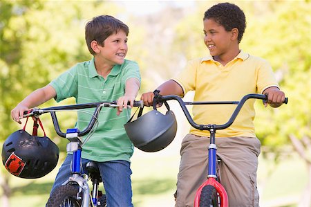 simsearch:400-04402106,k - Two young boys on bicycles outdoors smiling Fotografie stock - Microstock e Abbonamento, Codice: 400-04402105