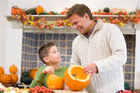 simsearch:400-07793720,k - Father and son carving jack o lanterns on Halloween and smiling Photographie de stock - Aubaine LD & Abonnement, Code: 400-04402190