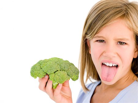 Young girl holding broccoli and sticking tongue out Stock Photo - Budget Royalty-Free & Subscription, Code: 400-04402341