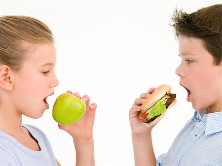 simsearch:400-04402341,k - Sister eating apple by brother eating cheeseburger Stock Photo - Budget Royalty-Free & Subscription, Code: 400-04402359