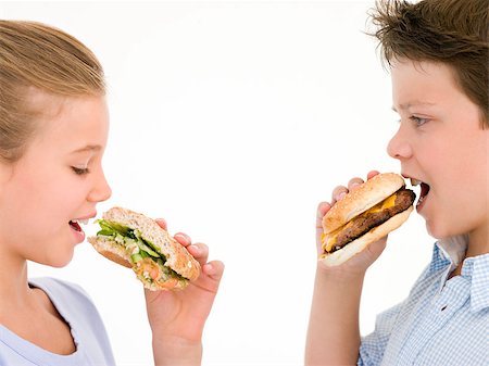 simsearch:400-04402342,k - Sister eating apple by brother eating cheeseburger Stock Photo - Budget Royalty-Free & Subscription, Code: 400-04402360